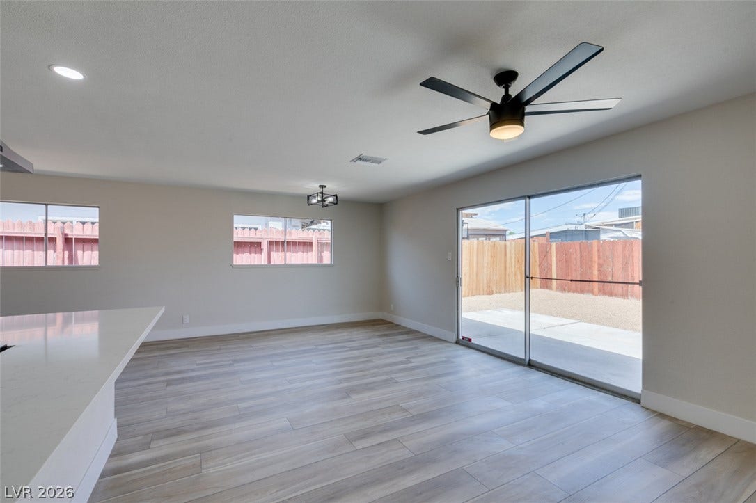 Sliding glass doors open directly to the fenced backyard from this light-filled living area.