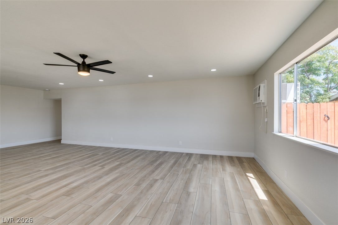 A spacious, open interior featuring plank flooring, smooth walls, and abundant natural light.