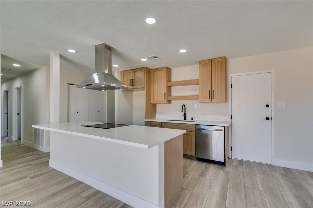 Clean lines and warm wood accents define this updated kitchen space with built-in appliances.