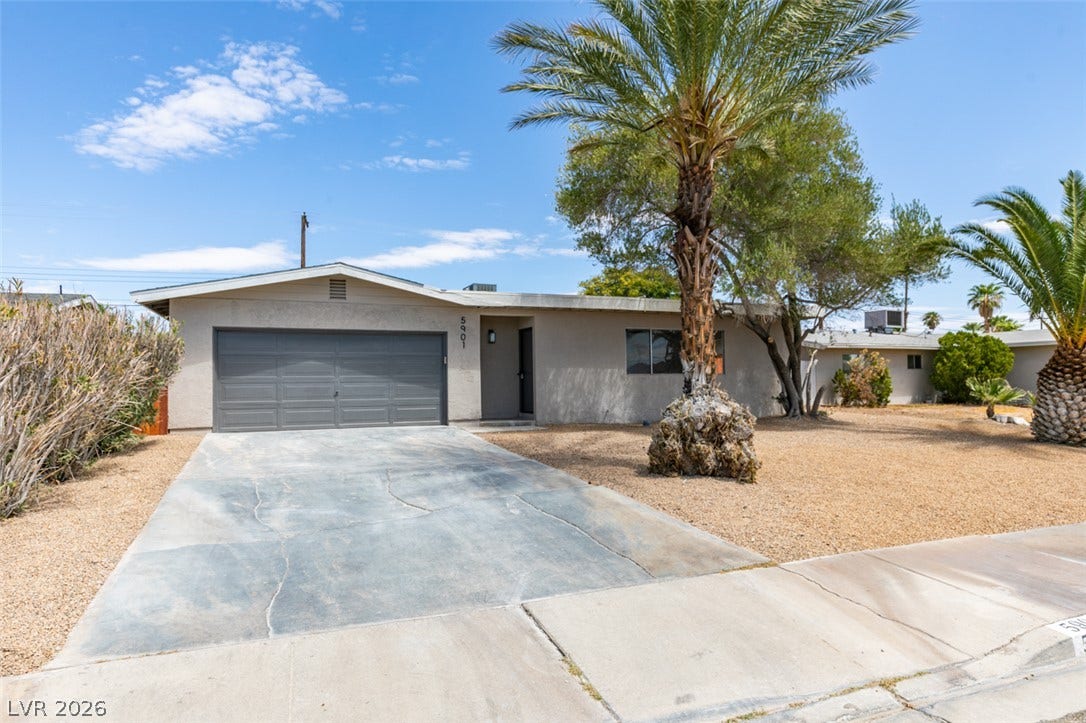 A classic ranch exterior pairs stucco walls with palm trees on a low-maintenance yard.