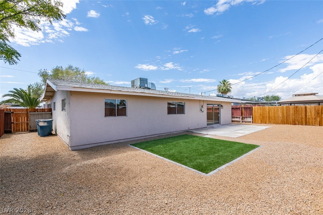 Fenced backyard features a low-maintenance gravel landscape and a concrete patio pad.