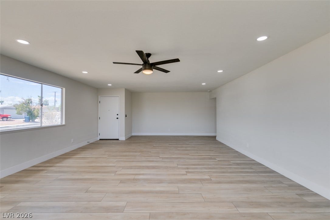 Smooth wood-look flooring and clean white walls define this open interior space.