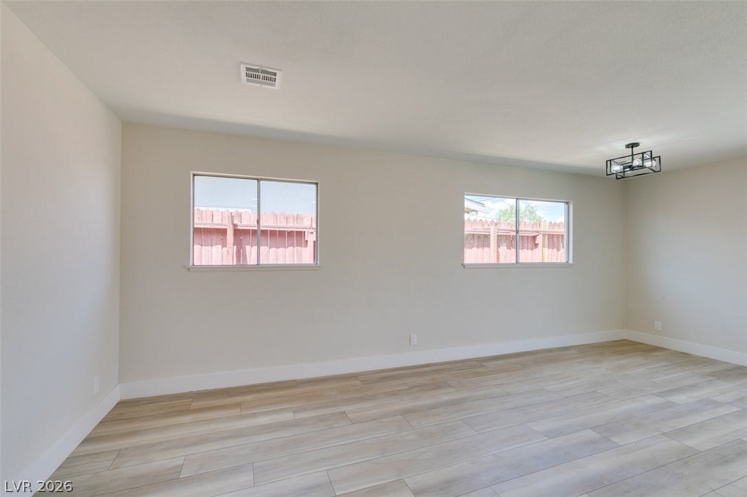 Clean lines and light-toned flooring define this versatile interior space with dual windows.