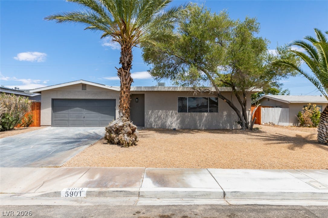 Mid-century architecture shines with low-maintenance desert landscaping and integrated two-car garage.