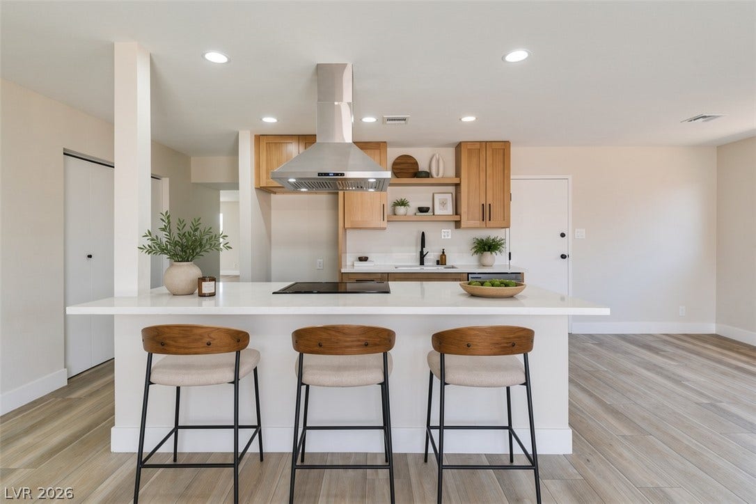 Virtually Staged Clean lines and a spacious island anchor this updated culinary workspace with wood-look flooring.