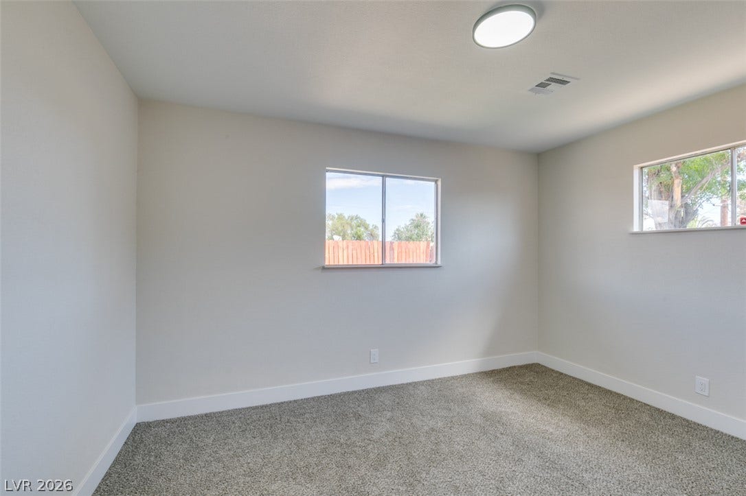 Plush carpeting and dual windows create a comfortable, well-lit secondary bedroom space.
