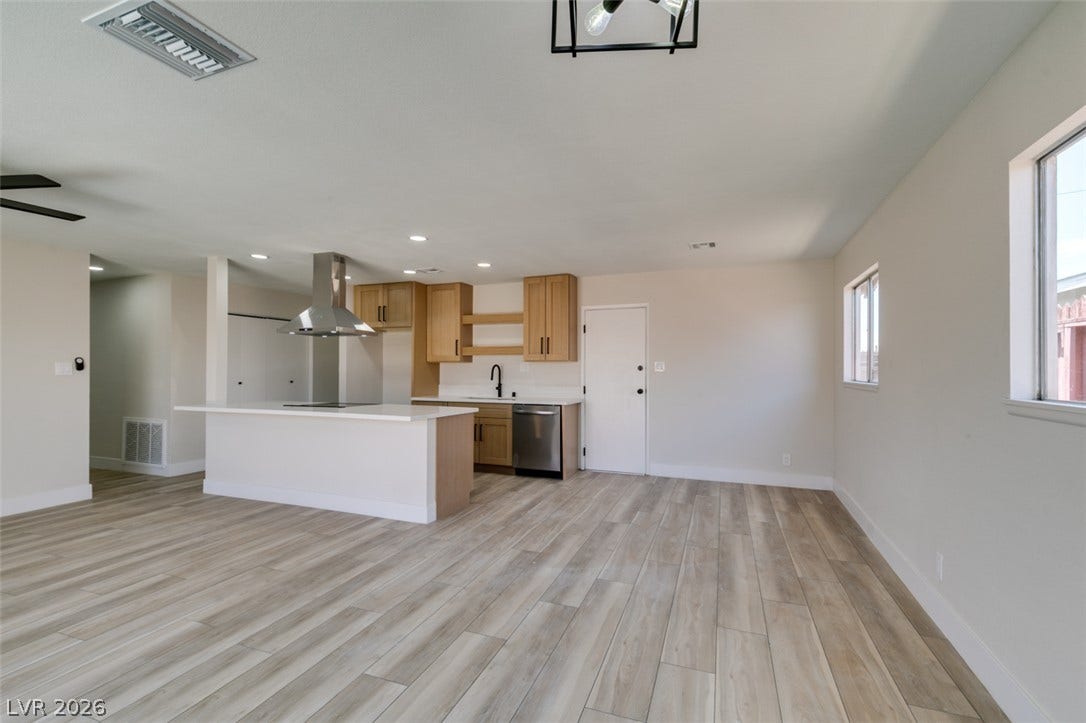An open floorplan seamlessly connects the airy living area to a modern, fully equipped kitchen.