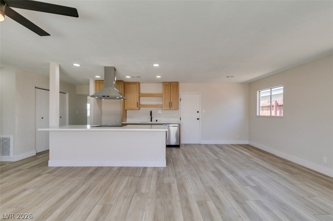 Clean lines and wood-look flooring define this open-concept culinary and living space.