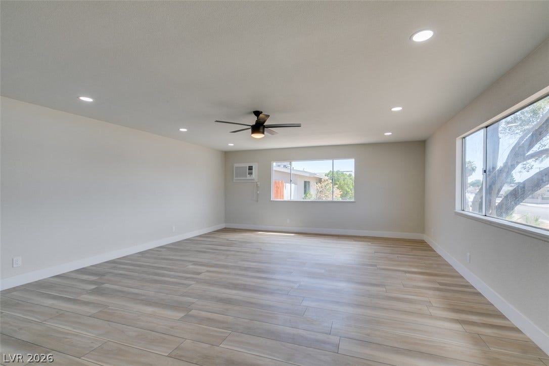 Recessed lighting and wood-look flooring enhance this generous living area.