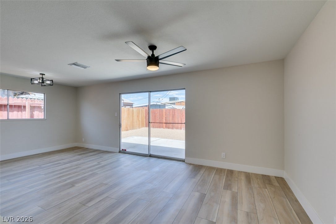 Wood-look flooring and sliding glass doors leading outside define this versatile open living space.