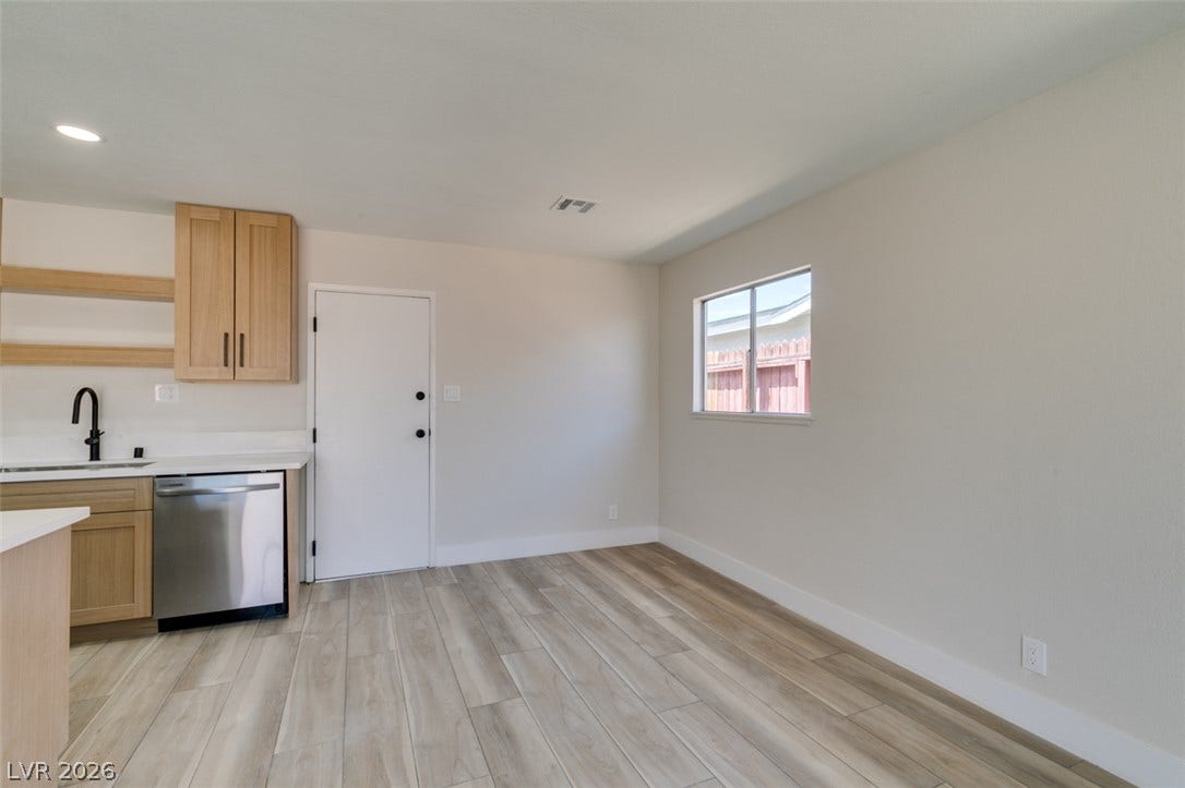 Clean lines and durable wood-look flooring define this versatile dining area adjacent to the kitchen.