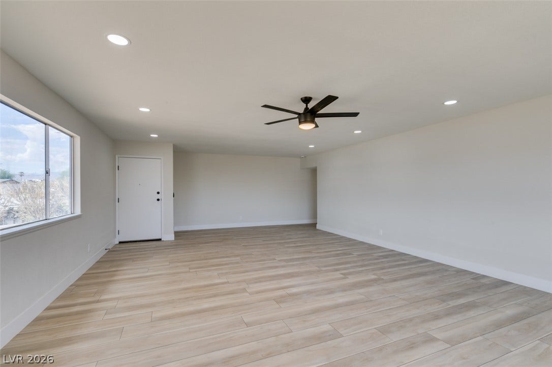 An open and airy living space is anchored by seamless wood-look flooring.