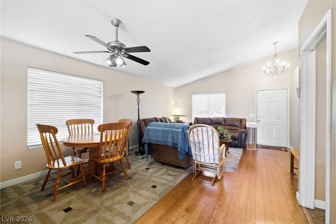 Warm hardwood floors and vaulted ceilings create an inviting and open living and dining area.