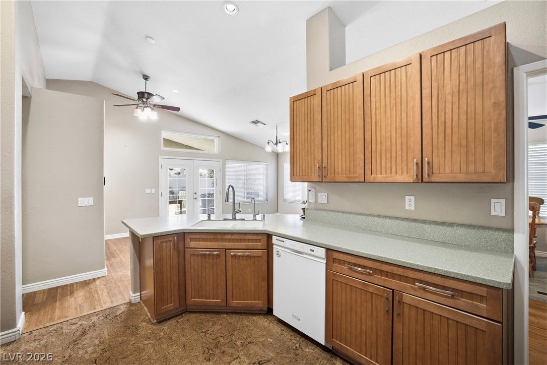 High vaulted ceilings and rich wood cabinetry define this functional workspace with dual-level flooring.