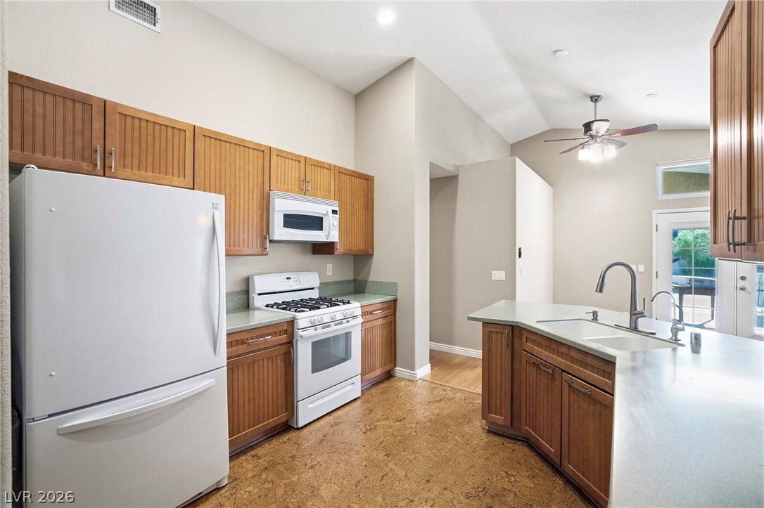 Warm wood cabinetry pairs with vaulted ceilings in this functional kitchen layout.