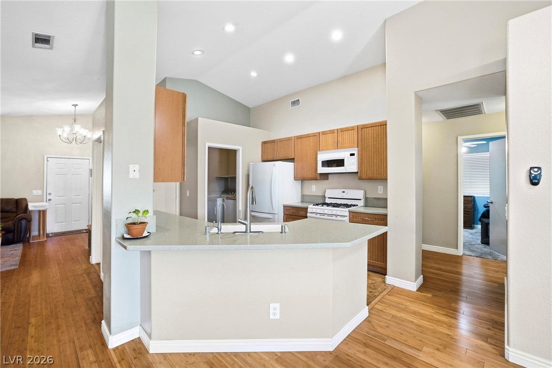 Vaulted ceilings and warm wood floors frame this open-concept kitchen.
