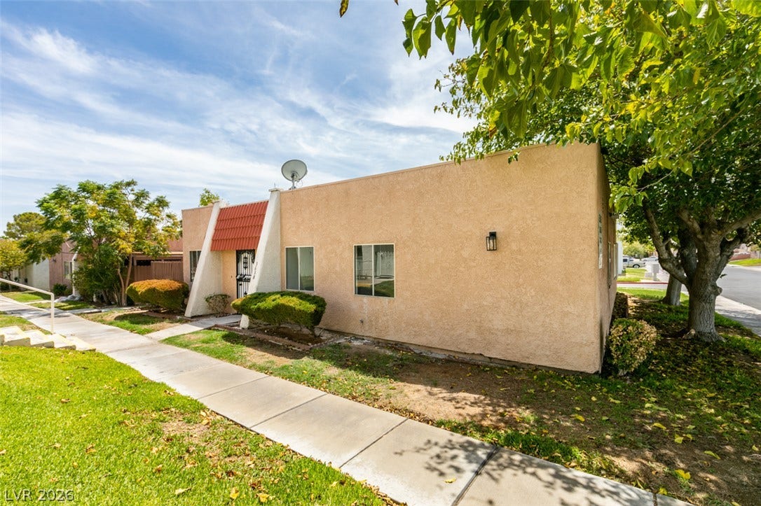 3638 Villa Knolls East Drive, Las Vegas, NV 89120 Mid-century architectural lines define this stucco exterior featuring a tiled accent roof over the entry.