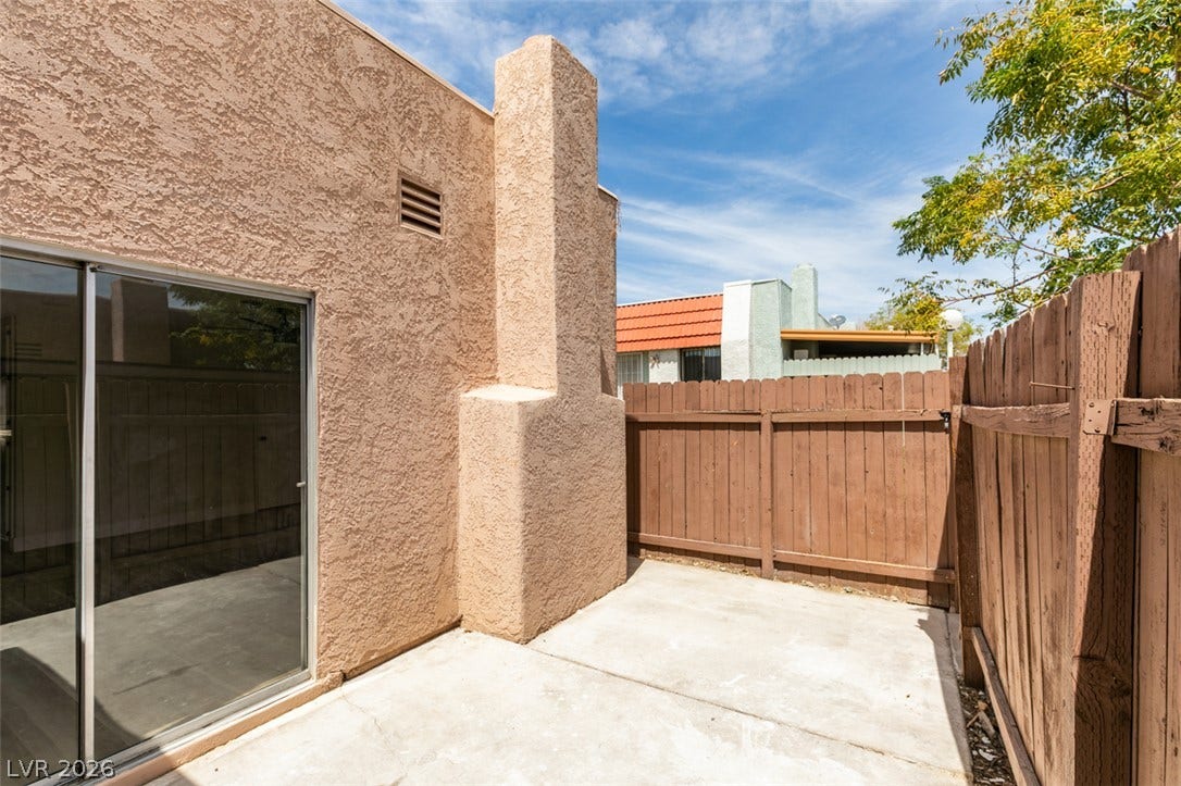 3638 Villa Knolls East Drive, Las Vegas, NV 89120 An enclosed concrete patio is bordered by stucco walls and a tall wooden privacy fence.