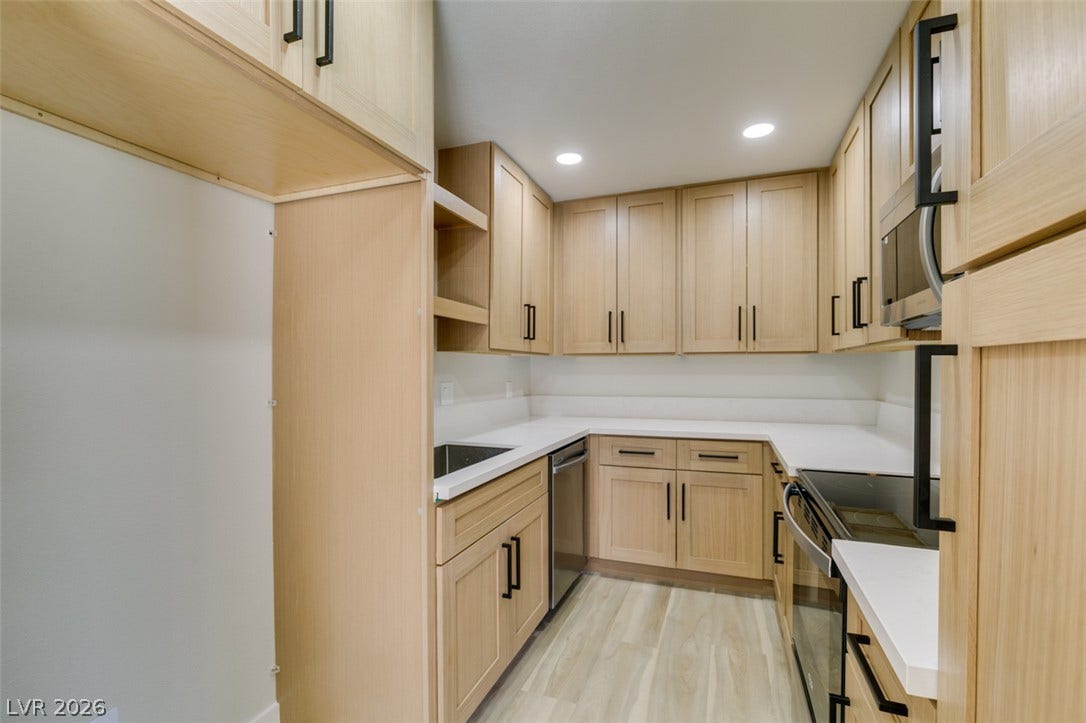 3638 Villa Knolls East Drive, Las Vegas, NV 89120 Natural wood cabinetry and crisp solid surface countertops define this streamlined modern kitchen.