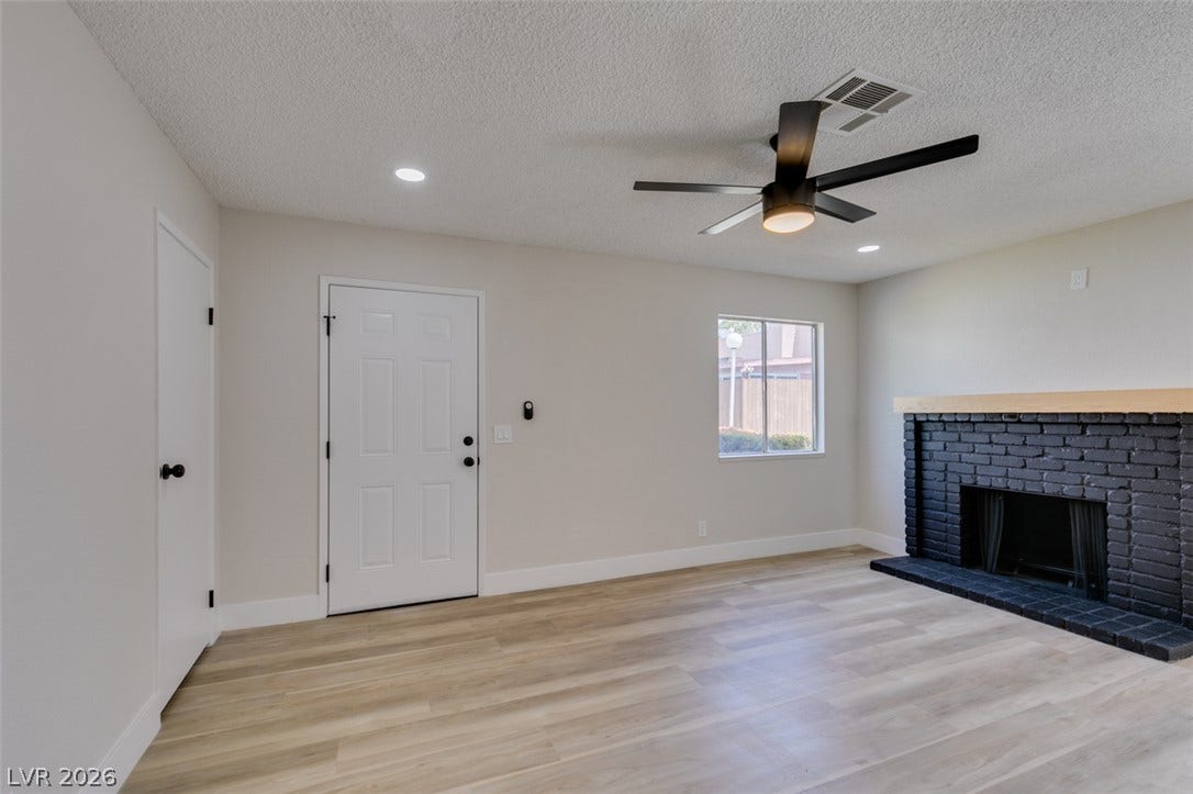 3638 Villa Knolls East Drive, Las Vegas, NV 89120 Smooth wood-look flooring and a brick fireplace anchor this welcoming entryway living space.