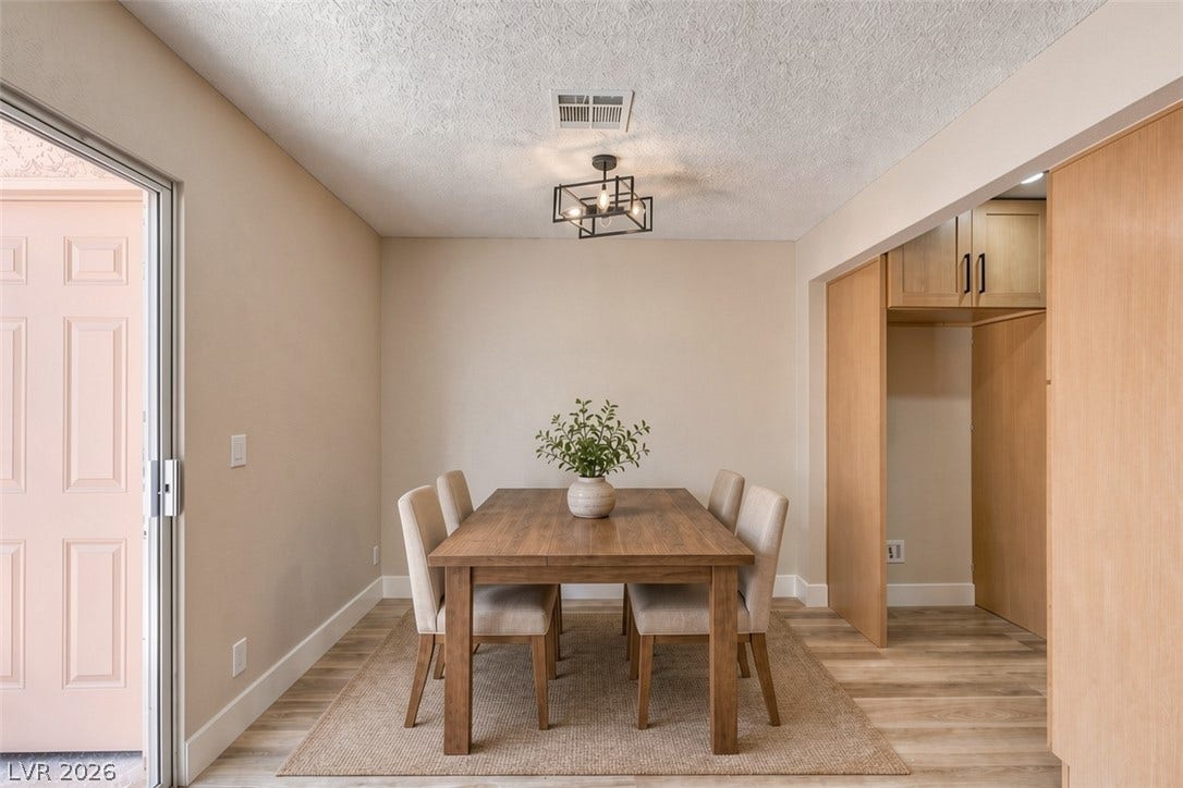3638 Villa Knolls East Drive, Las Vegas, NV 89120 Virtually Staged Sliding glass doors open to this dining space featuring wood-plank flooring and clean lines.