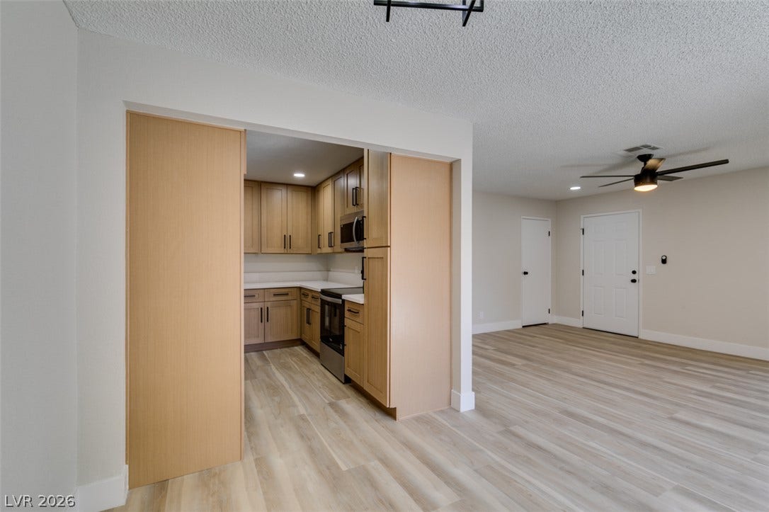 3638 Villa Knolls East Drive, Las Vegas, NV 89120 Smooth wood-look flooring connects an inviting kitchen threshold directly to the main living space.