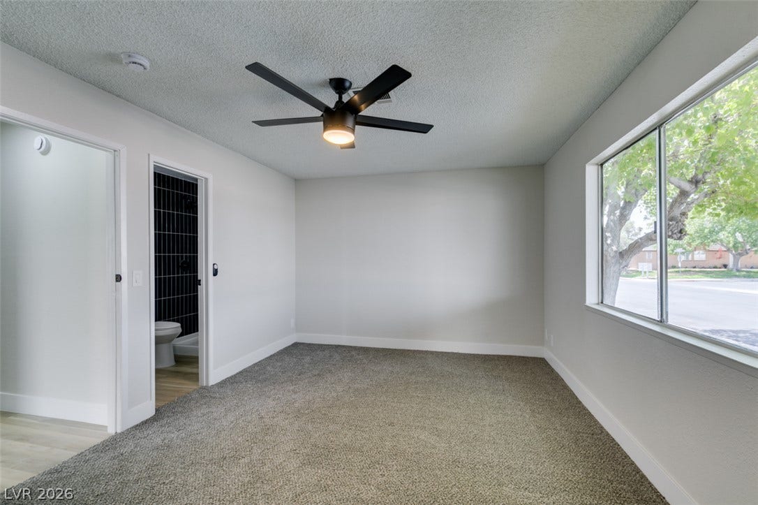 3638 Villa Knolls East Drive, Las Vegas, NV 89120 Soft carpeting pairs with a large window offering neighborhood views in this bedroom.