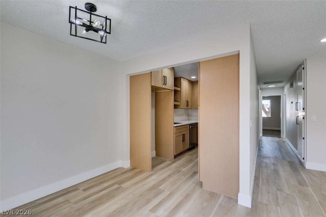 3638 Villa Knolls East Drive, Las Vegas, NV 89120 An open doorway connects the dining area with the kitchen, showcasing modern wood flooring.