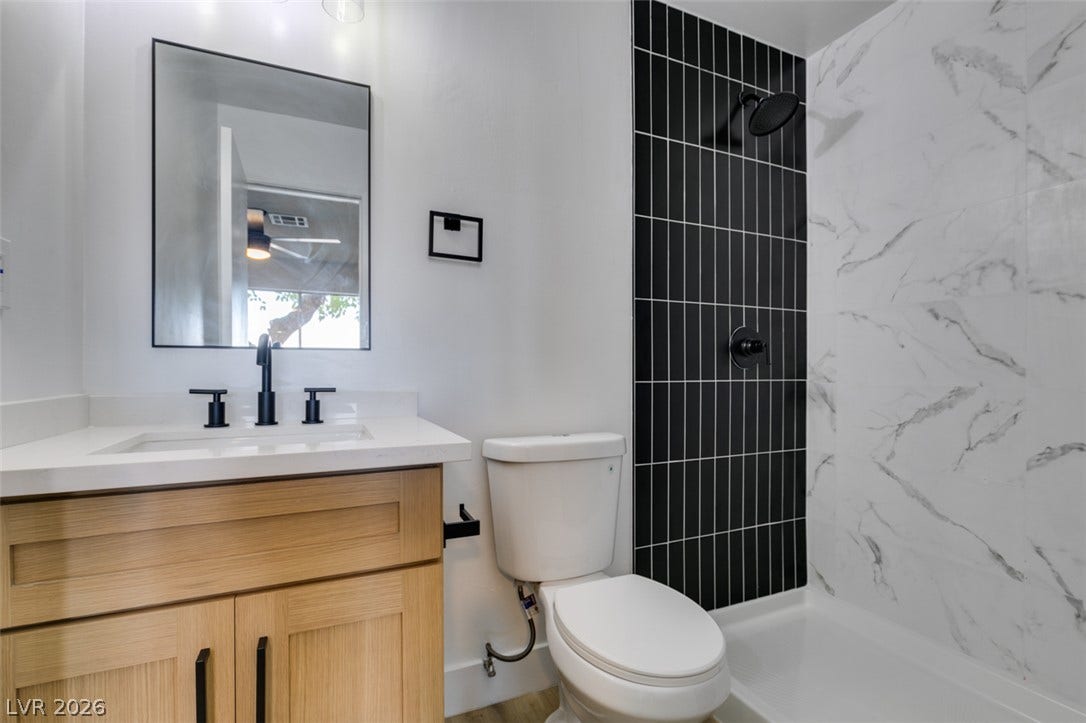 3638 Villa Knolls East Drive, Las Vegas, NV 89120 Modern finishes define this bathroom featuring a glass-enclosed shower with contrasting custom tilework.