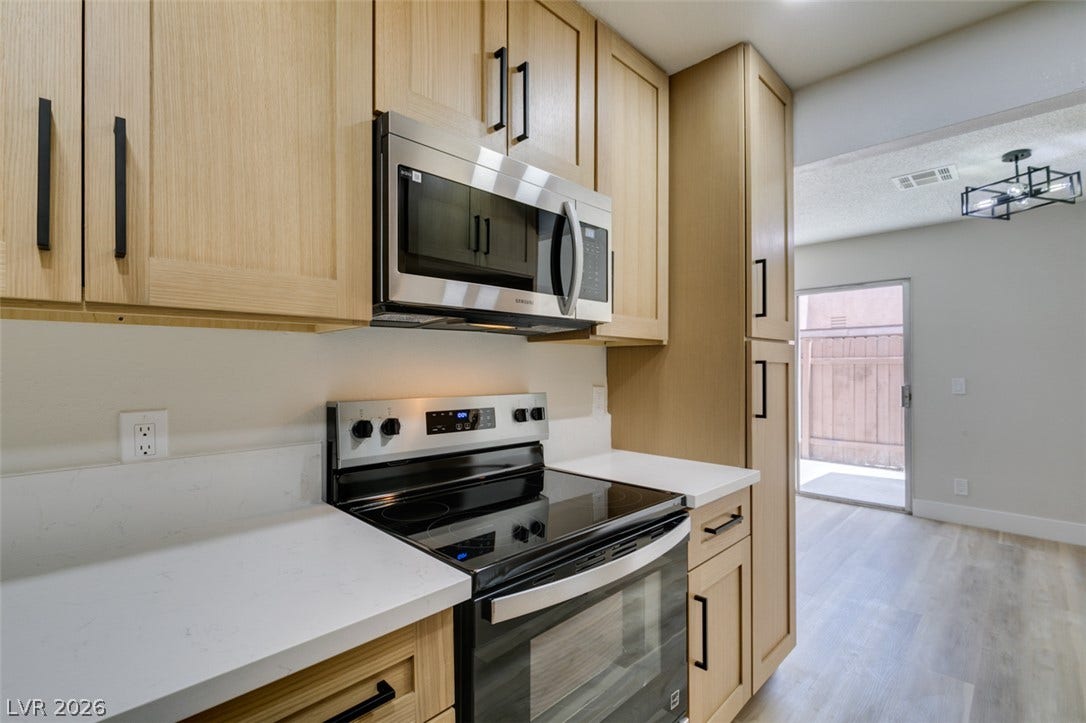3638 Villa Knolls East Drive, Las Vegas, NV 89120 Crisp quartz countertops and modern wood cabinetry define this open culinary workspace.