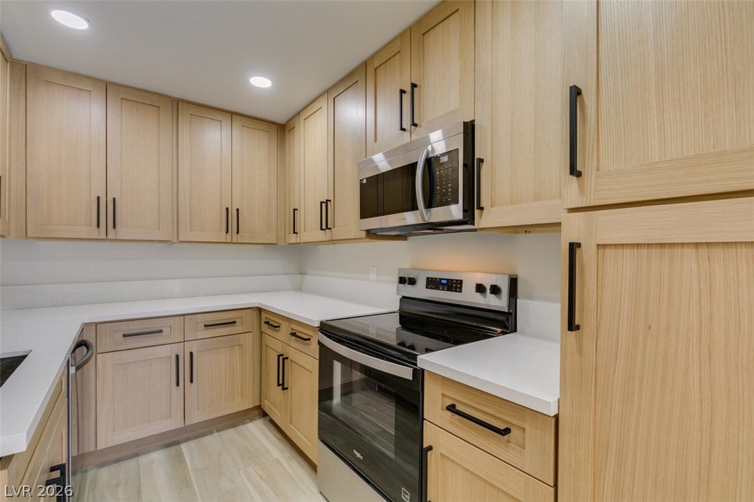 3638 Villa Knolls East Drive, Las Vegas, NV 89120 Recessed lighting illuminates clean countertops and light wood cabinetry in this functional space.