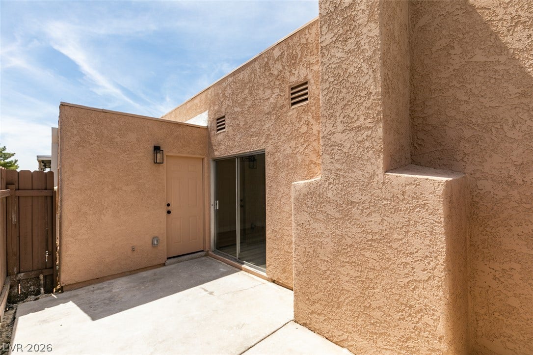 3638 Villa Knolls East Drive, Las Vegas, NV 89120 Concrete patio framed by stucco exterior walls and sliding glass doors.