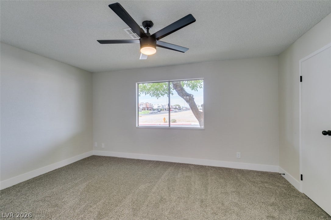 3638 Villa Knolls East Drive, Las Vegas, NV 89120 Plush carpeting and a large window framing neighborhood views anchor this comfortable bedroom.