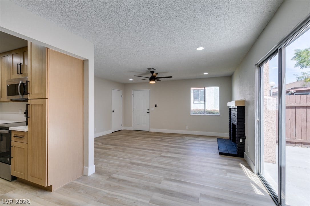 3638 Villa Knolls East Drive, Las Vegas, NV 89120 Sliding glass doors open to the patio from this living area featuring a brick fireplace.