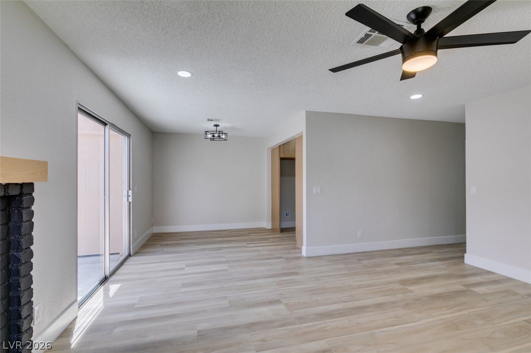 3638 Villa Knolls East Drive, Las Vegas, NV 89120 Sliding glass doors open to the patio from this spacious living area with wood-look flooring.