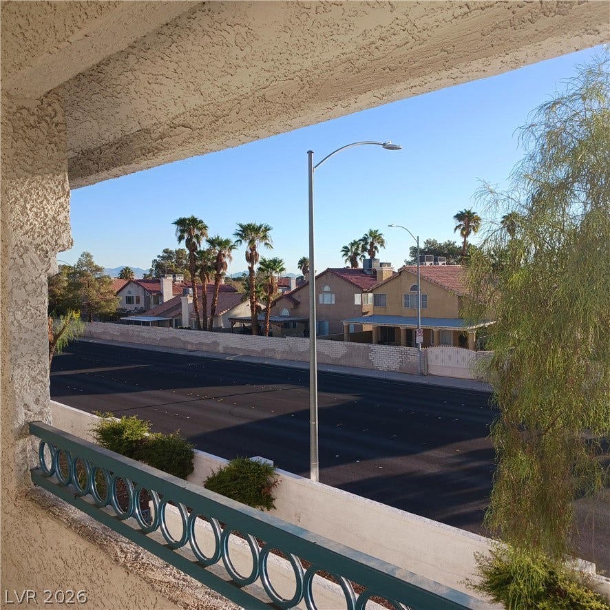 Clear blue skies and neighborhood views frame this outdoor vantage point from the balcony.
