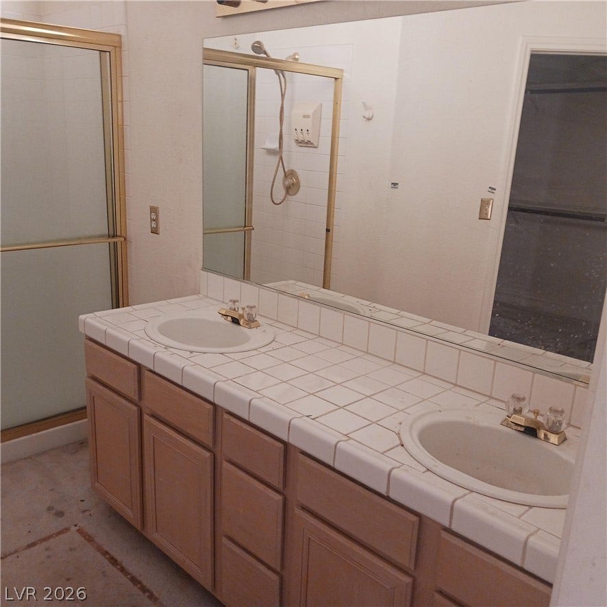 A spacious double vanity and a glass-enclosed shower highlight this classic bathroom.