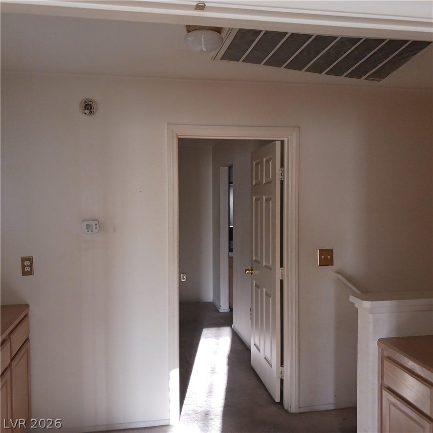 A classic doorway connects distinct spaces over soft carpeting.