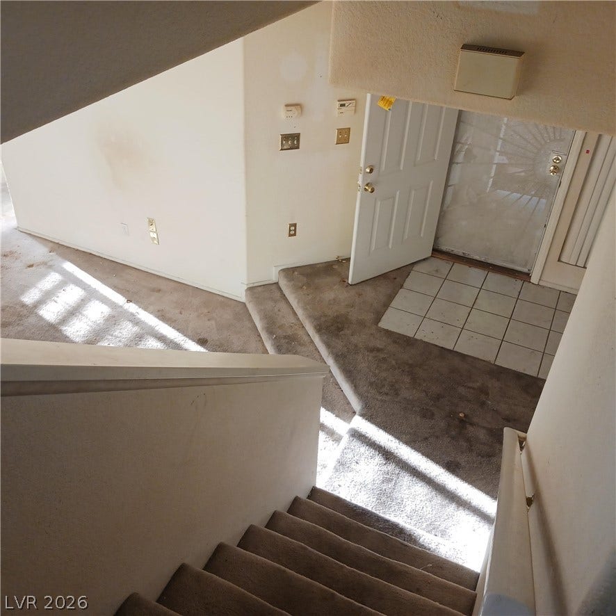 A spacious multi-level foyer entry is viewed from the overlooking staircase.