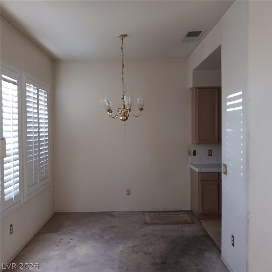 A spacious dining area features plantation shutters and leads directly into the kitchen.