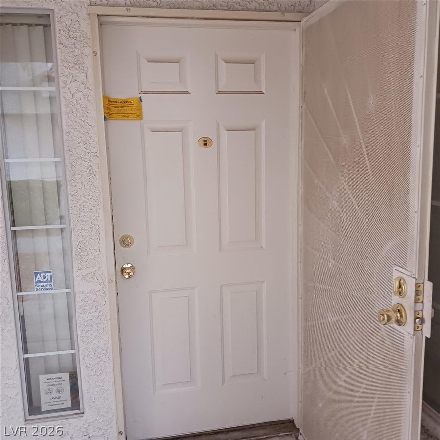 A paneled front door opens to the exterior entry alongside a sidelight window.