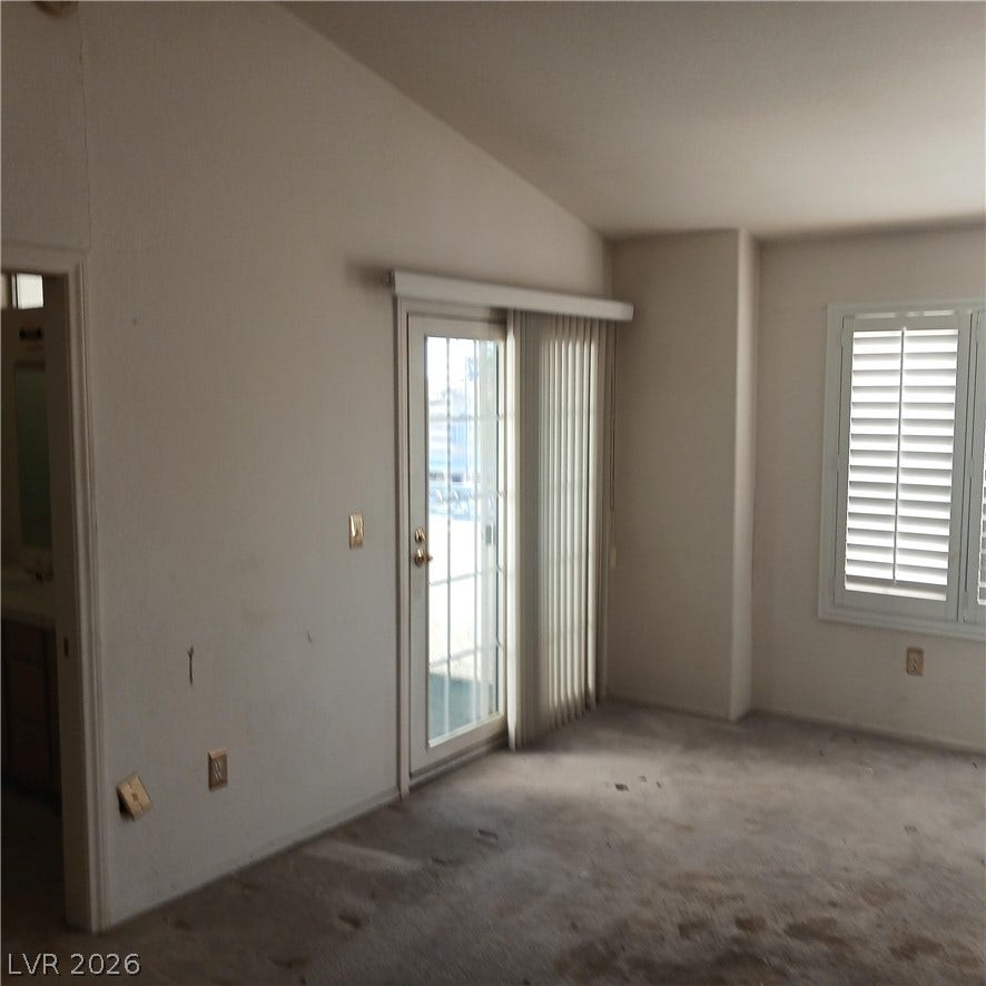 Angled ceilings and sliding glass doors introduce natural light into this versatile living area.