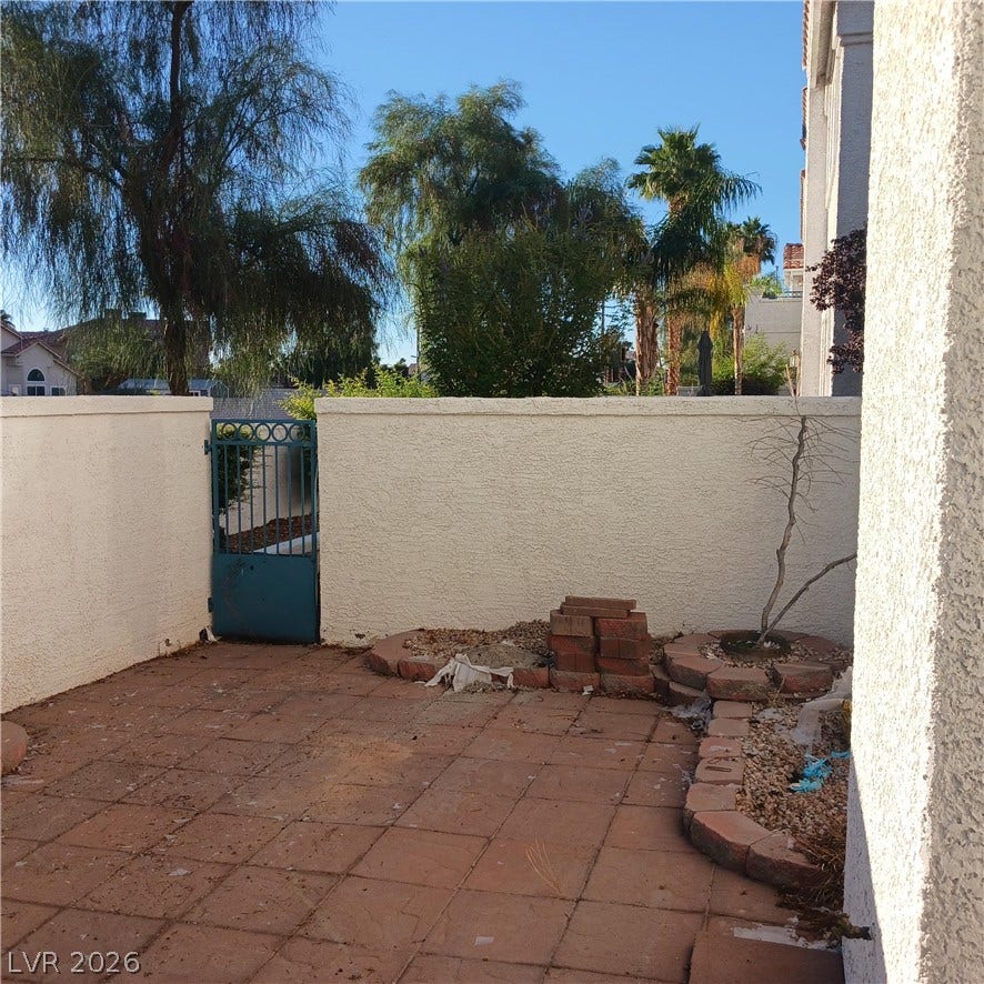 A private walled patio offers low-maintenance tile flooring and a gated entrance.
