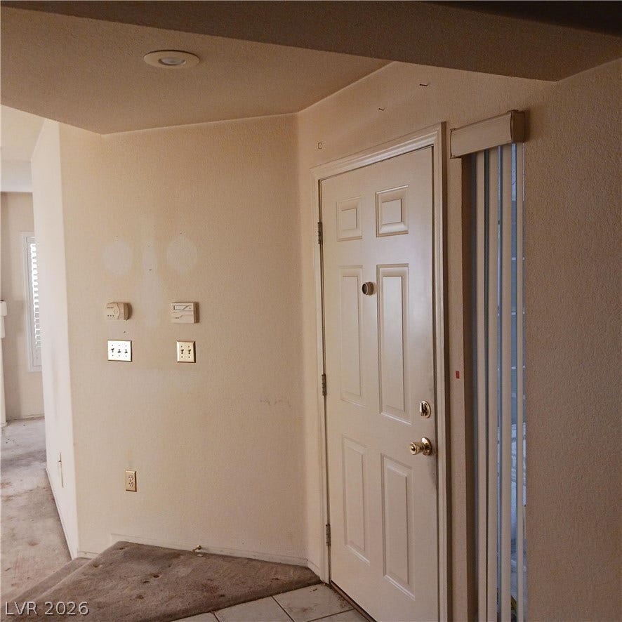 An inviting entryway welcomes guests with a tiled transition and recessed lighting.