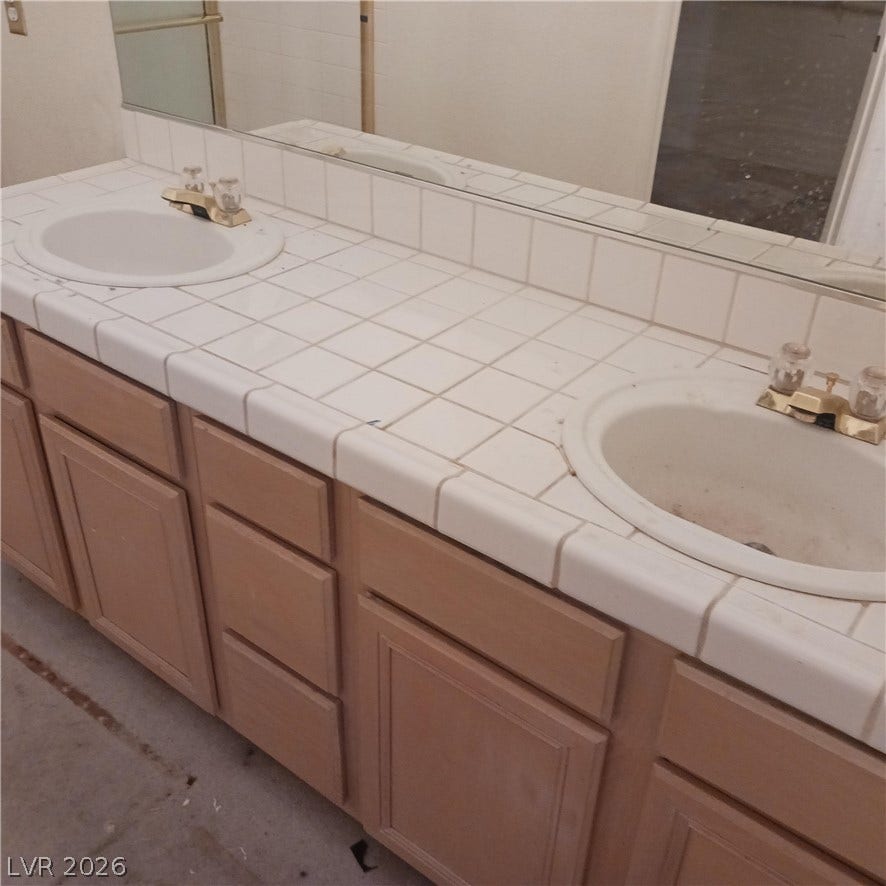 Tiled vanity countertops with dual sinks provide functional space ready for personal updates.