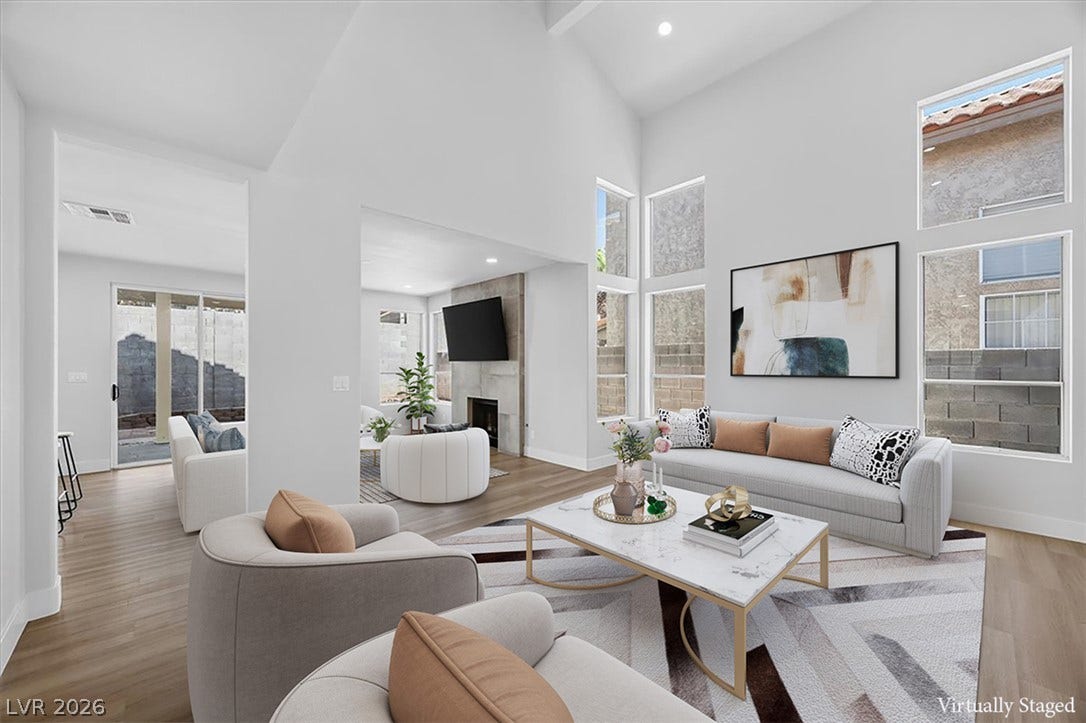 136 Villaggio Street, Henderson, NV 89074 Soaring ceilings and tall windows anchor this bright, open living space over wood flooring.