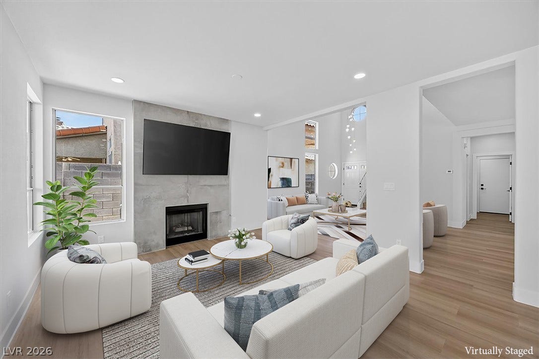 136 Villaggio Street, Henderson, NV 89074 An inviting fireplace serves as the focal point in this open living space with hardwood flooring.