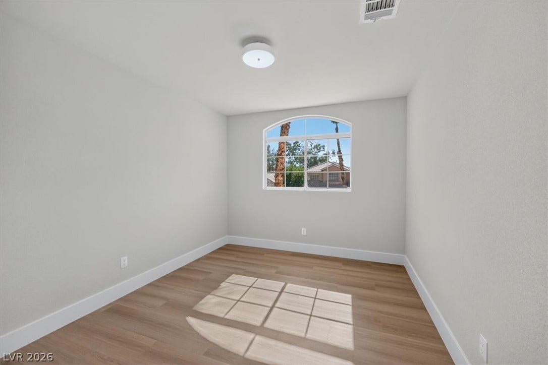 136 Villaggio Street, Henderson, NV 89074 Warm wood flooring and an arched window define this versatile interior space.