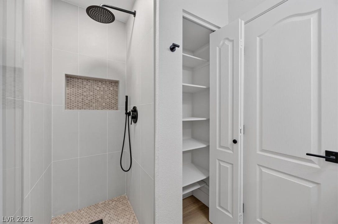 136 Villaggio Street, Henderson, NV 89074 Tiled shower walls and a built-in linen closet elevate this functional space.