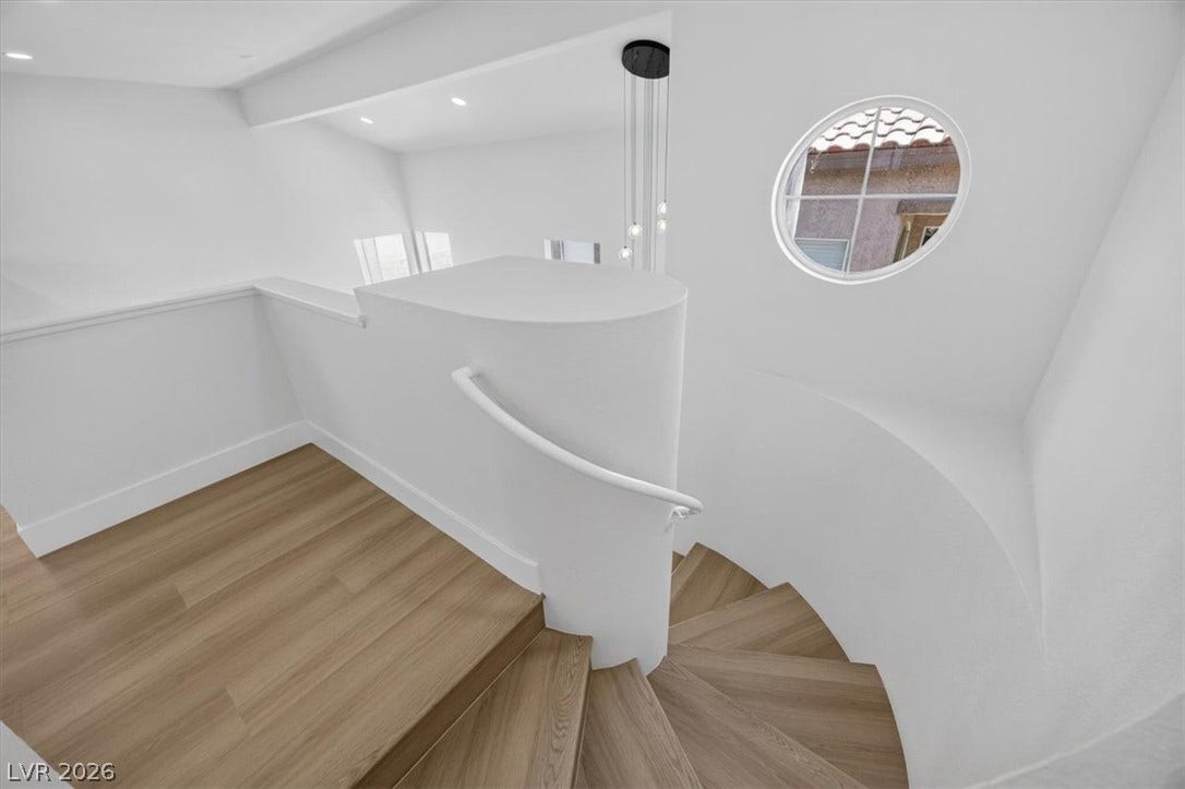 136 Villaggio Street, Henderson, NV 89074 Clean lines and a round window accent this curved staircase with modern wood steps.
